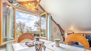A dining area with a table, chairs, and a view of the outdoors.