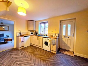 A compact kitchen with a washing machine, a microwave, and a sink. - Manor cottage annexe  (Kempsey)