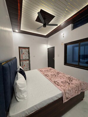 Camera da letto con un letto, una ventola a soffitto, una finestra e una porta.