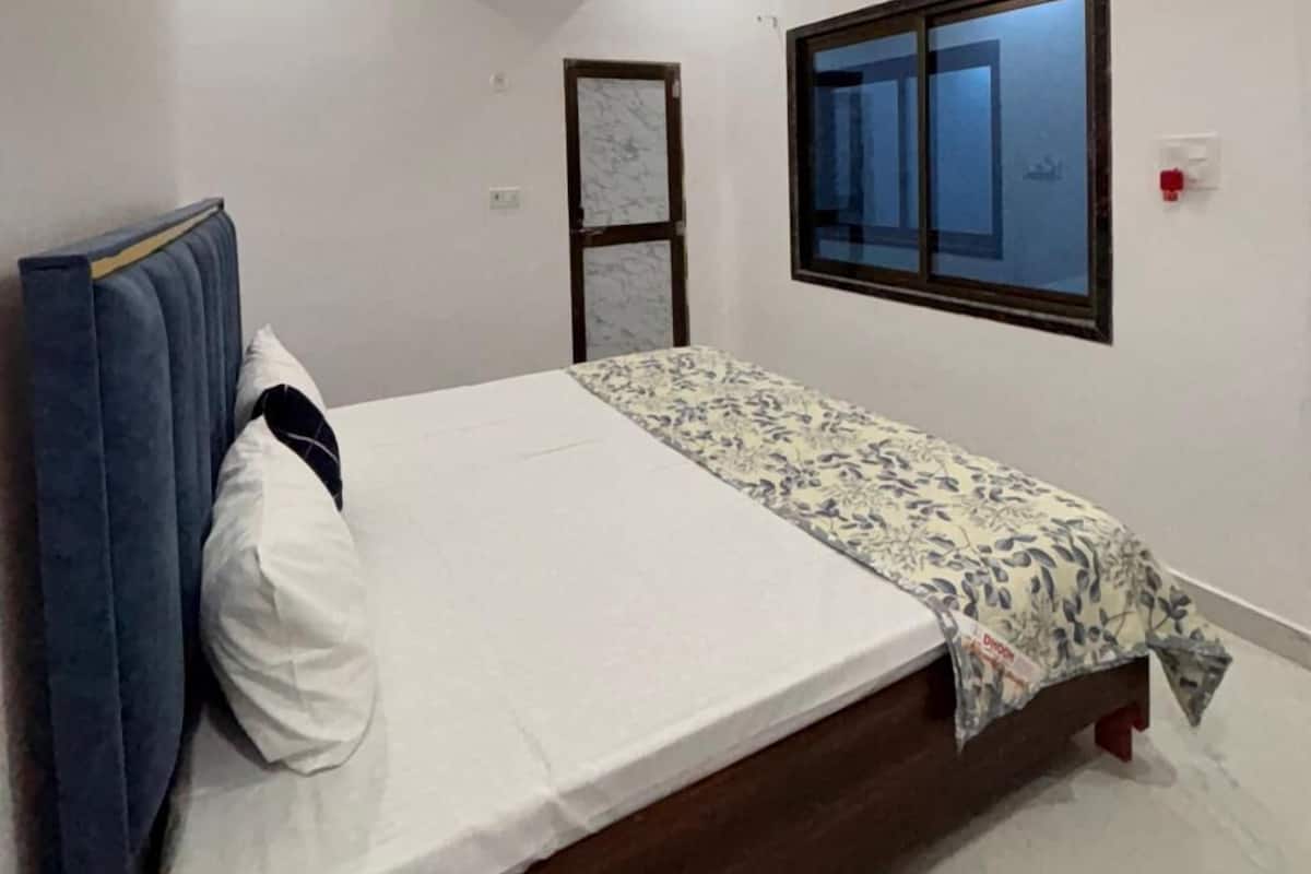 Een slaapkamer met een bed, een plafondventilator, een airconditioning en een raam en een deur.