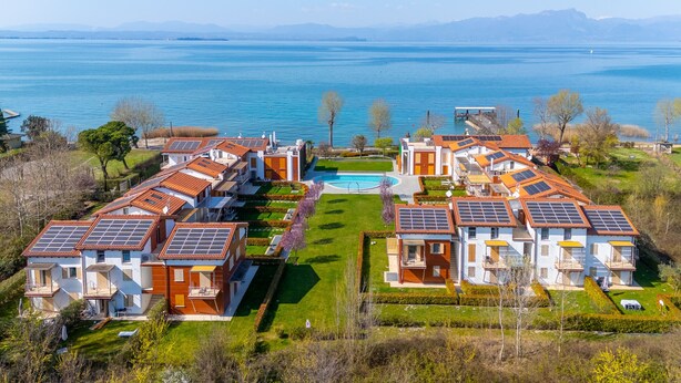 Un quartier résidentiel où les maisons sont dotées de panneaux solaires, d’une piscine et offrent une vue sur un lac.
