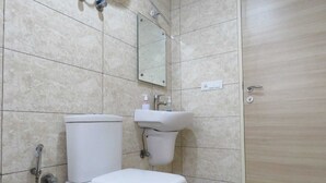 A bathroom with a toilet, sink, and a mirror. - Brij Darshan (Vrindavan)