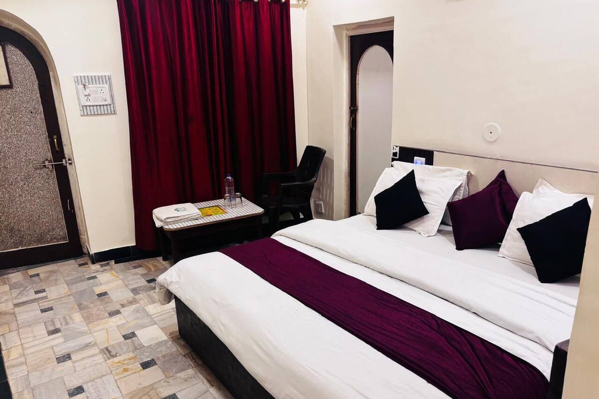 Une chambre d’hôtel avec un lit, un bureau et une chaise.