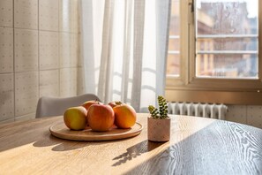 A wooden table with a plate of apples and a potted plant. - LUMINOSO APPARTAMENTO AL PIGNETO (ROMA)
