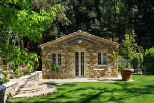 Una casa in pietra con un piccolo patio, un tavolo e una sedia.