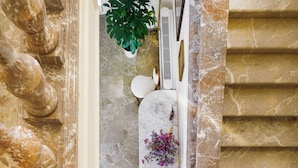 Una escalera de mármol con una consola blanca y una planta en maceta.