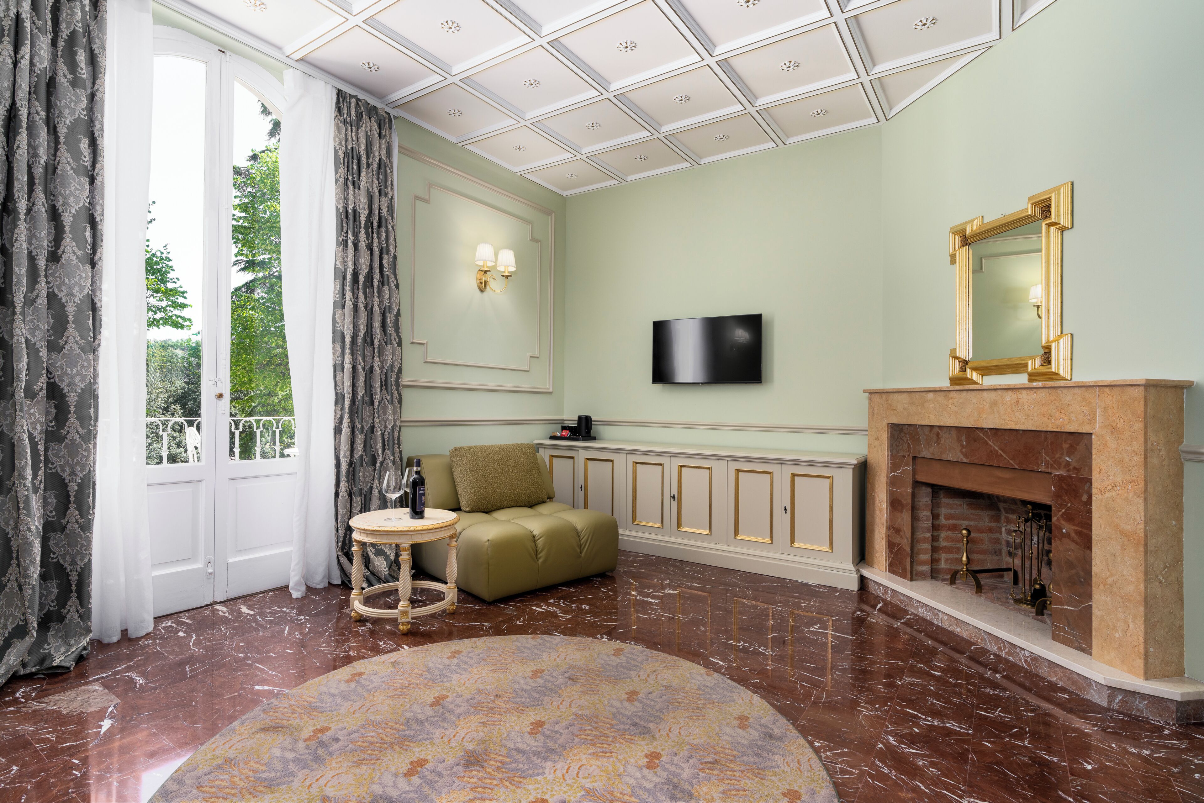 Une pièce avec une cheminée, un téléviseur, un canapé et un tapis à motifs.