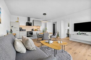 Un espace de vie moderne comprenant un canapé, une table basse et un coin repas.