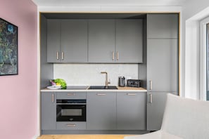 A modern kitchen with grey cabinets, a built-in oven, and a coffee machine. - The View B17 Boje 17 - Sea view, Sauna, shared. Washing machine,parking space (Dageb üll)