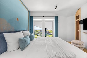 A bedroom with a large bed, a view of a residential area, and a wooden wardrobe. - The View B17 Boje 17 - Sea view, Sauna, shared. Washing machine,parking space (Dagebüll)
