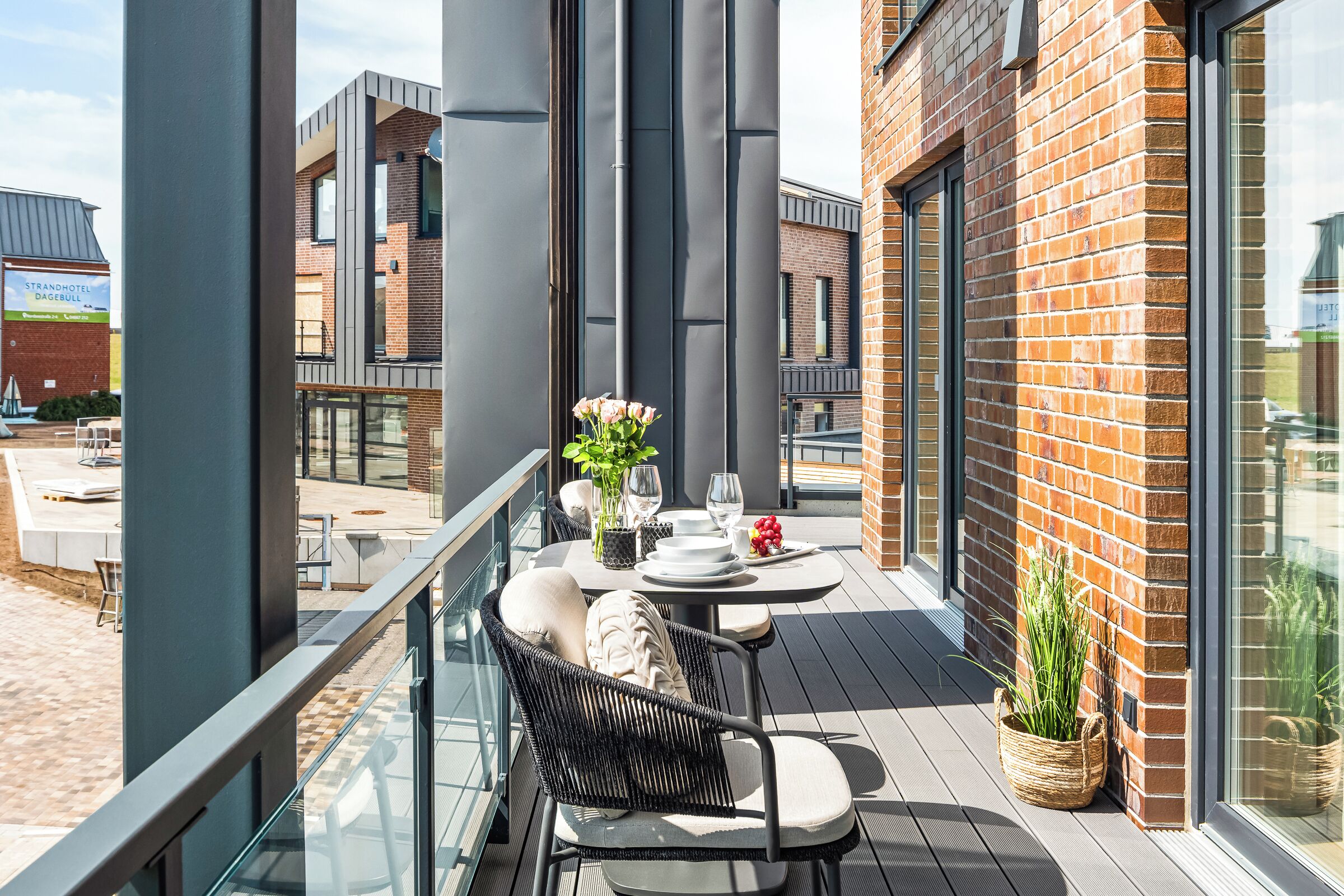 Ein Balkon mit Esstisch, Stuhl und einer Topfpflanze.