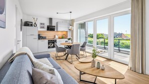 Een modern appartement met keuken, eethoek en een ruim balkon met uitzicht.