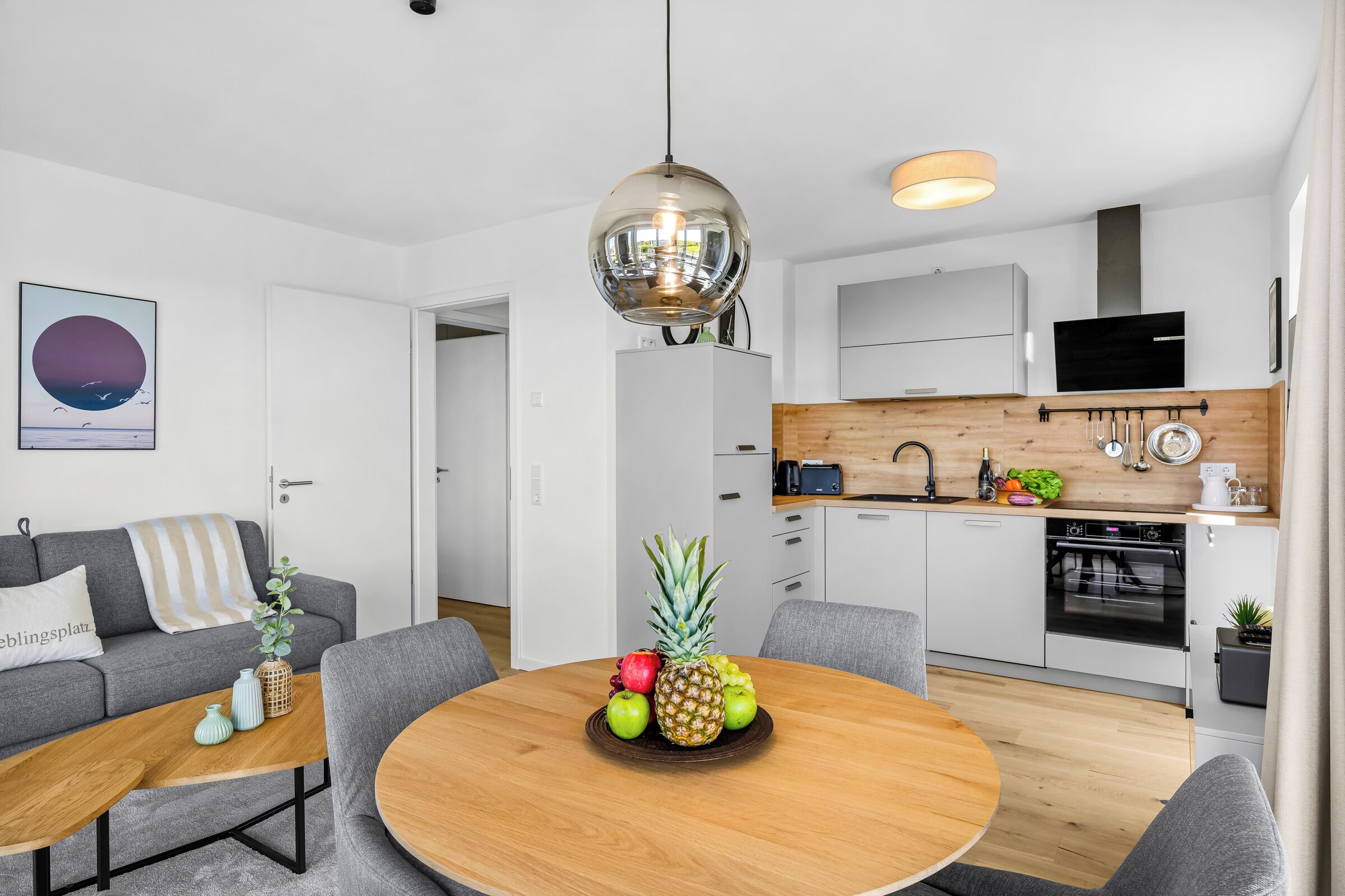 Een moderne keuken met witte kasten, een houten aanrechtblad en een ingebouwde oven.