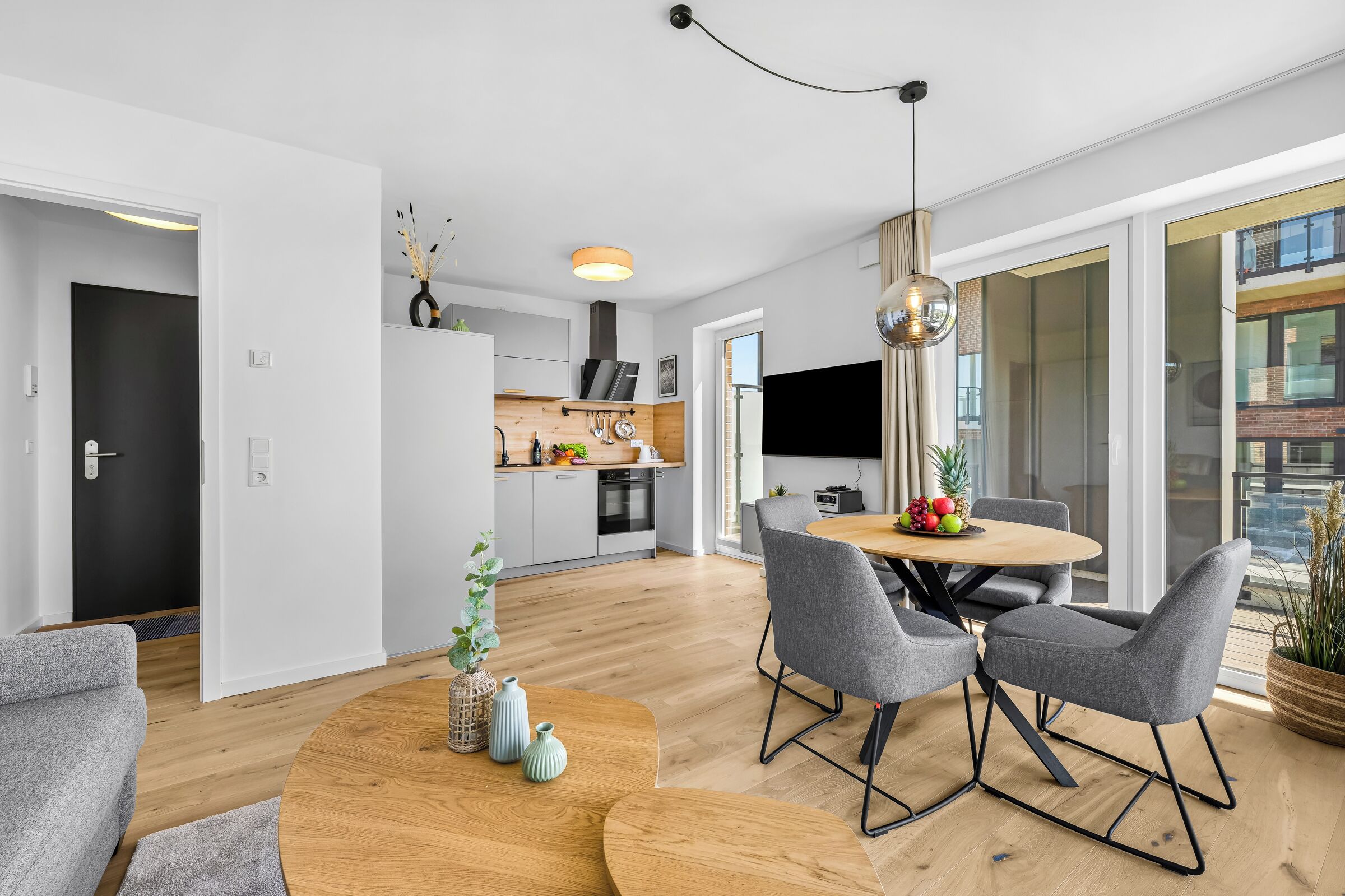 A modern kitchen with a dining area, a large window, and a view of the city.
