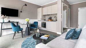 Un salon moderne avec un canapé, une table basse et un téléviseur fixé au mur.