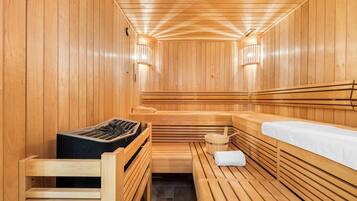 A sauna with wooden benches and a bench with a towel.