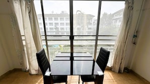 Una habitación con un ventanal grande, una mesa y dos sillas.