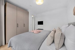 Ein Schlafzimmer mit einem Bett, einem Fernseher und einem Kleiderschrank.