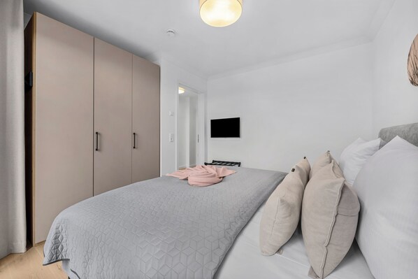 Un dormitorio con cama, televisión y armario.