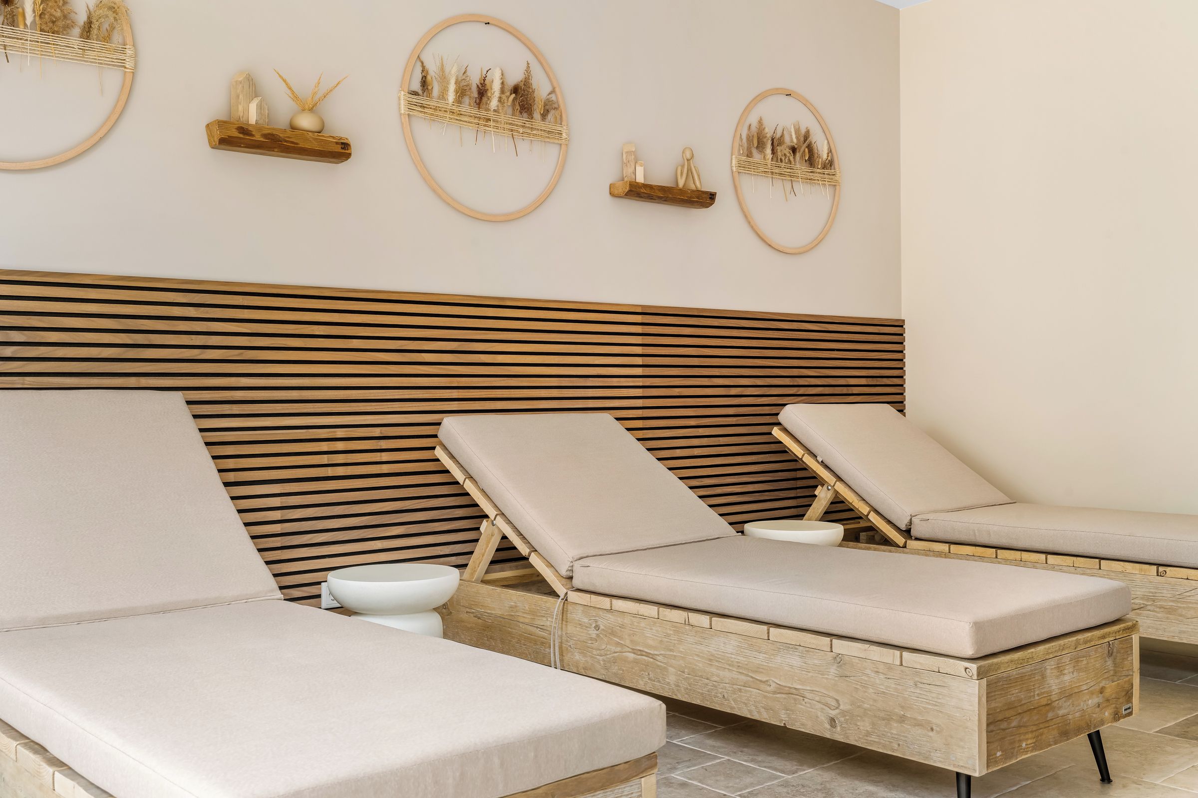Une salle de spa comprenant deux fauteuils, un mur avec des lambris en bois et des œuvres d’art décoratives.