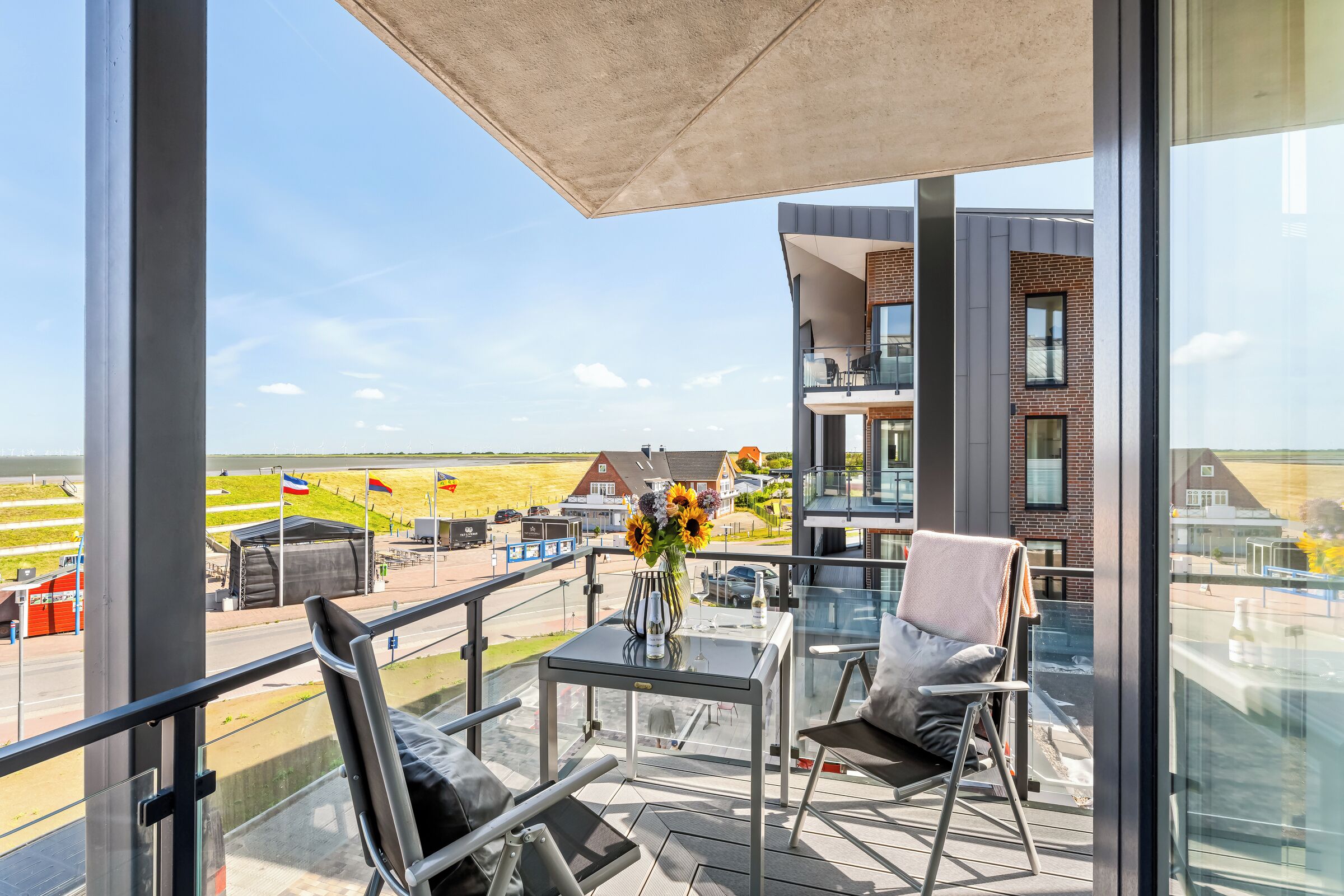 Ein Balkon mit Tisch, Stühlen und einem Blumenstrauß.