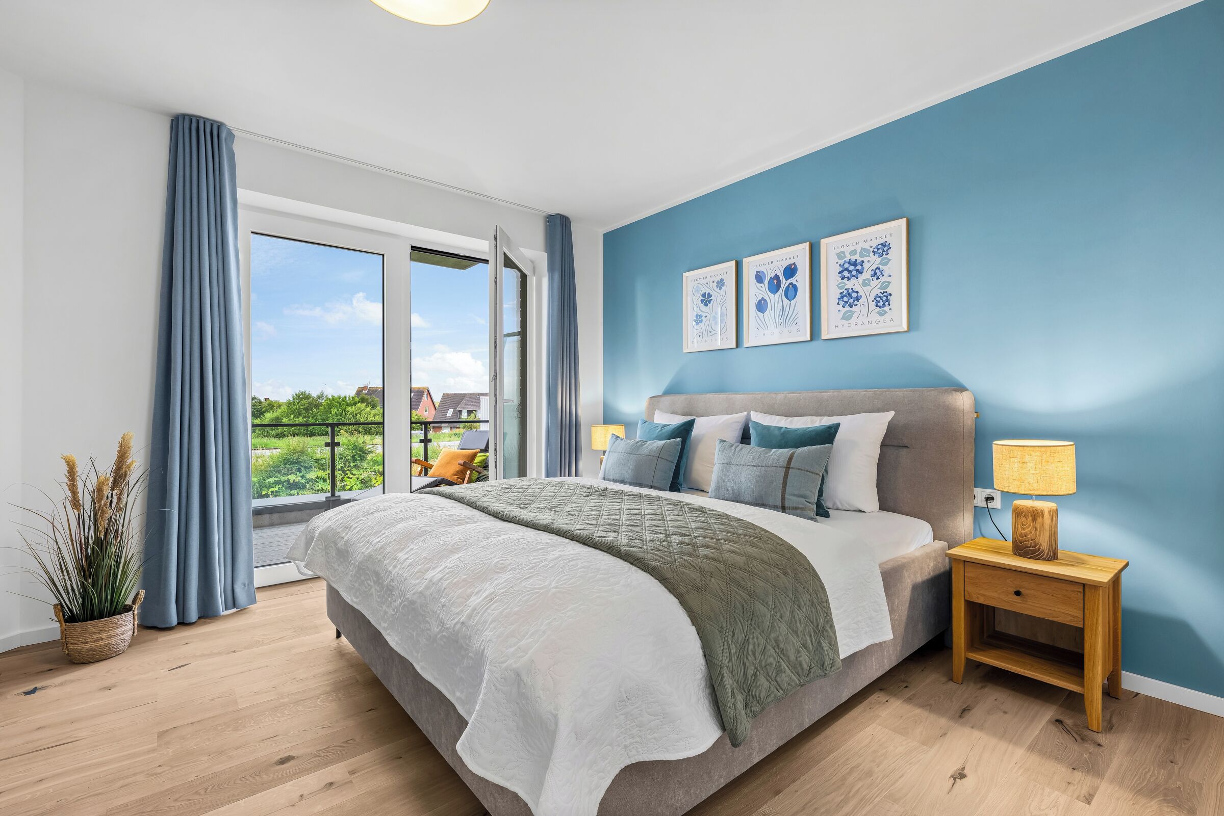 Een slaapkamer met een groot bed, een nachtkastje, een raam met gordijnen, en twee decoratieve wandpanelen.