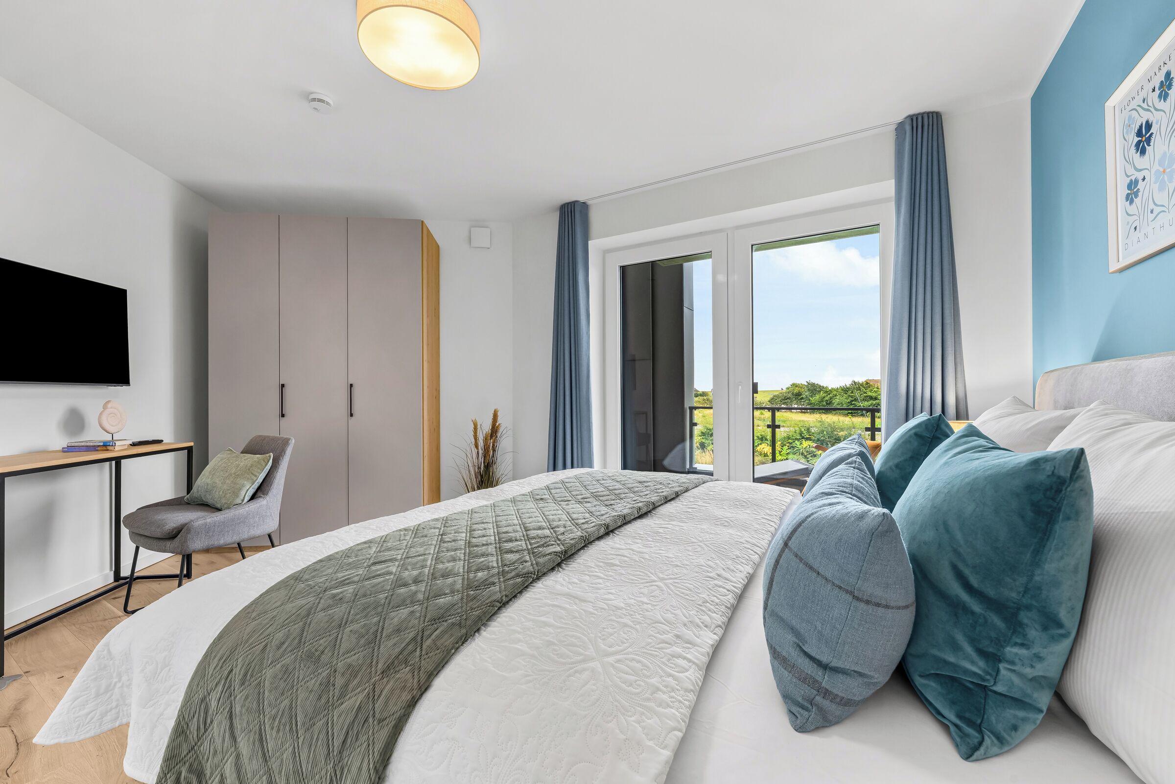 Een moderne slaapkamer met een bed, een bureau en een stoel.