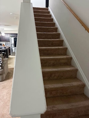 A carpeted staircase with a white handrail leading to an upper floor. - Modern 4BR Near Uptown Charlotte (Charlotte)
