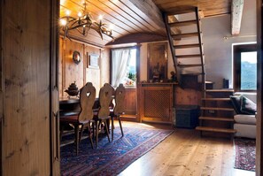 A wooden interior with a dining area, staircase, and a view of the outdoors. - Classy typical apartment in Alvera' (Cortina d'Ampezzo)