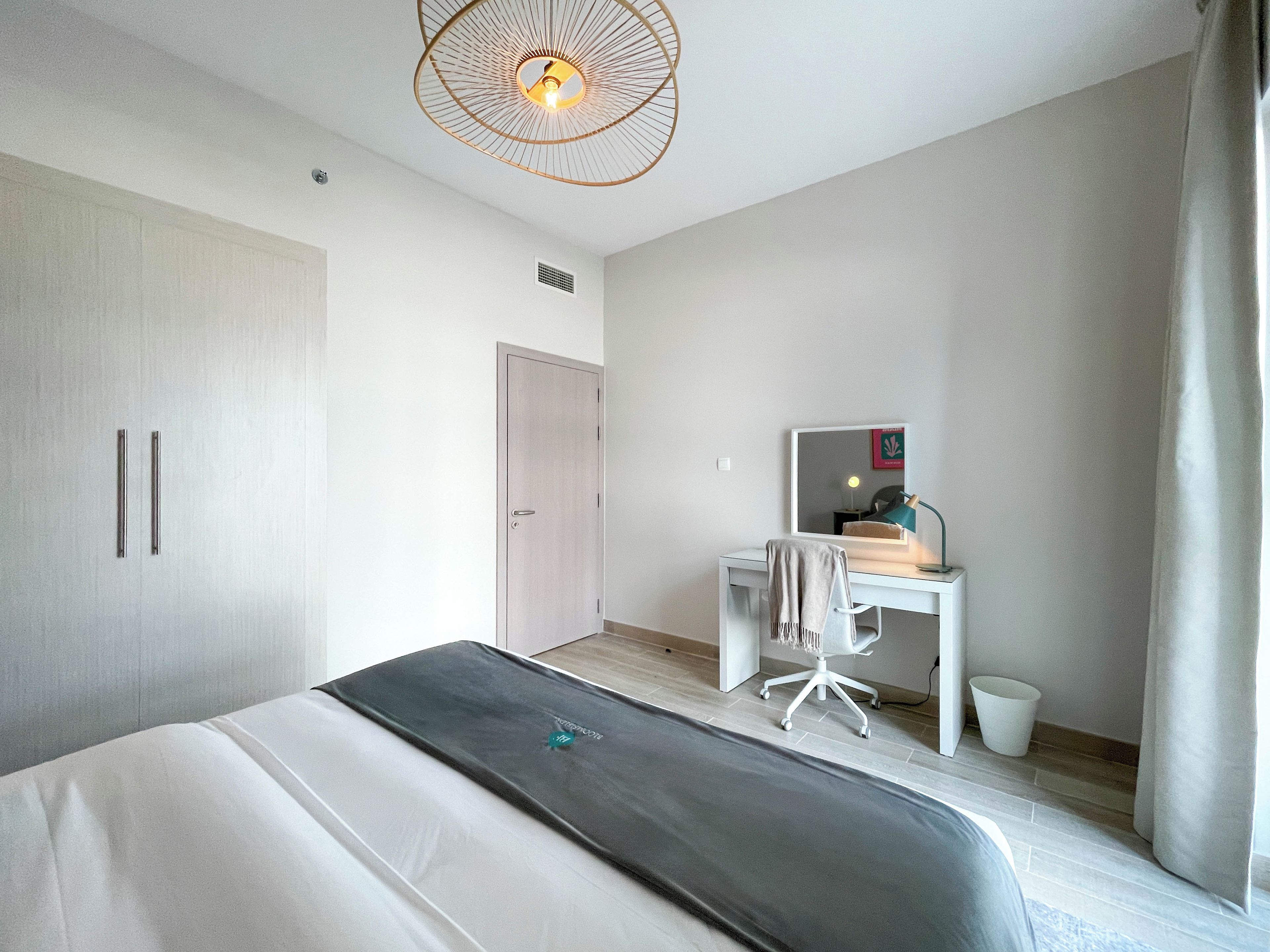 Een moderne slaapkamer met een bed, een bureau en een stoel.