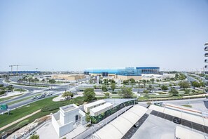 A modern urban intersection with a large blue building, multiple roads, and green spaces. - Bloomfields Relaxing 1-Br in Yas Is (Abu Dhabi)