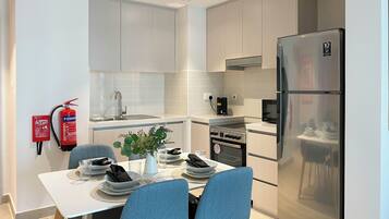 Una cocina moderna con comedor, electrodomésticos de acero inoxidable y un extintor.