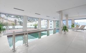 Ein modernes Hallenbad mit freiem Blick auf Stadt und Berge.