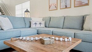 Un salón con un sofá azul claro, una mesa de centro de madera y objetos decorativos.