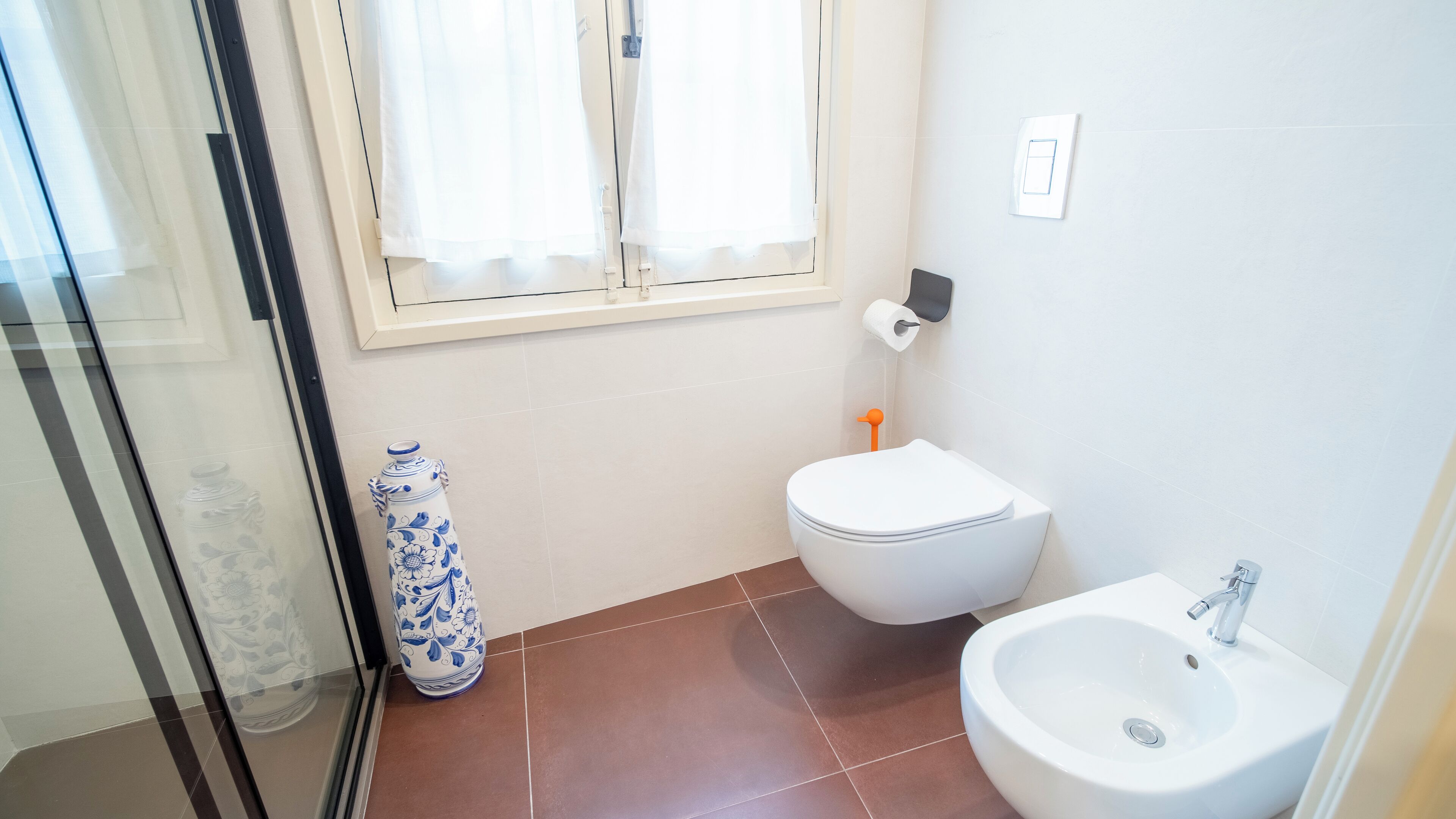 A bathroom with a toilet, bidet, and sink.