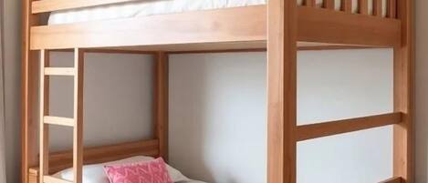Un lit superposé avec une échelle, un bureau et une chaise.