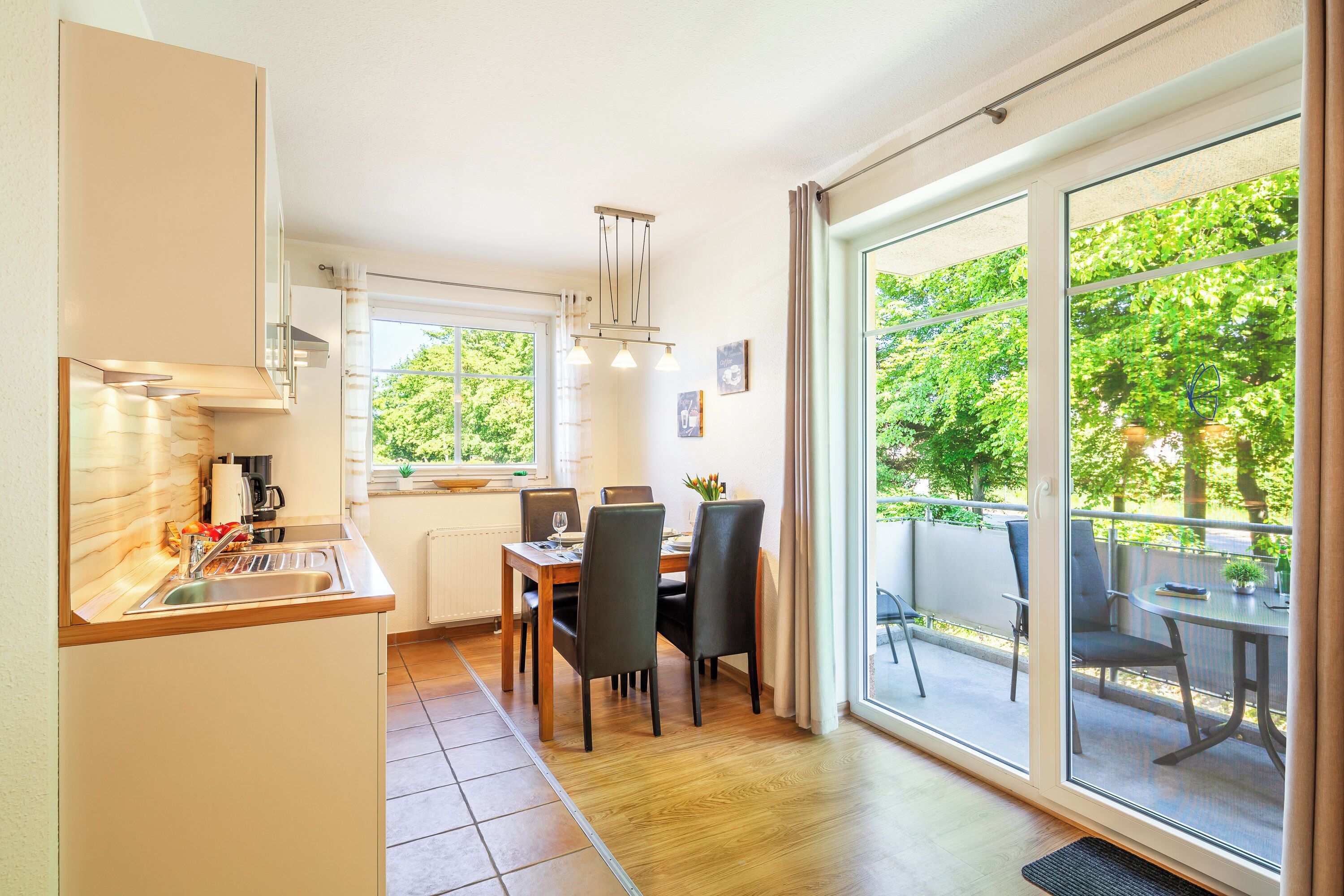 A modern kitchen with a dining area and large sliding glass doors leading to an outdoor patio.