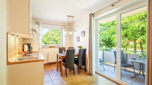 Una cucina moderna con zona pranzo e ampie porte scorrevoli in vetro che si aprono su un patio esterno.