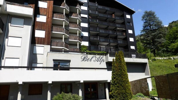 A multi-story hotel with balconies, a sign reading "Bel Alp," and a well-maintained garden area. - Apartment in Saint Gervais Near Cable Car (Saint-Gervais-les-Bains)