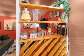Ein Holzregal mit Dekoration, einem gerahmten Bild und einer kleinen Pflanze.