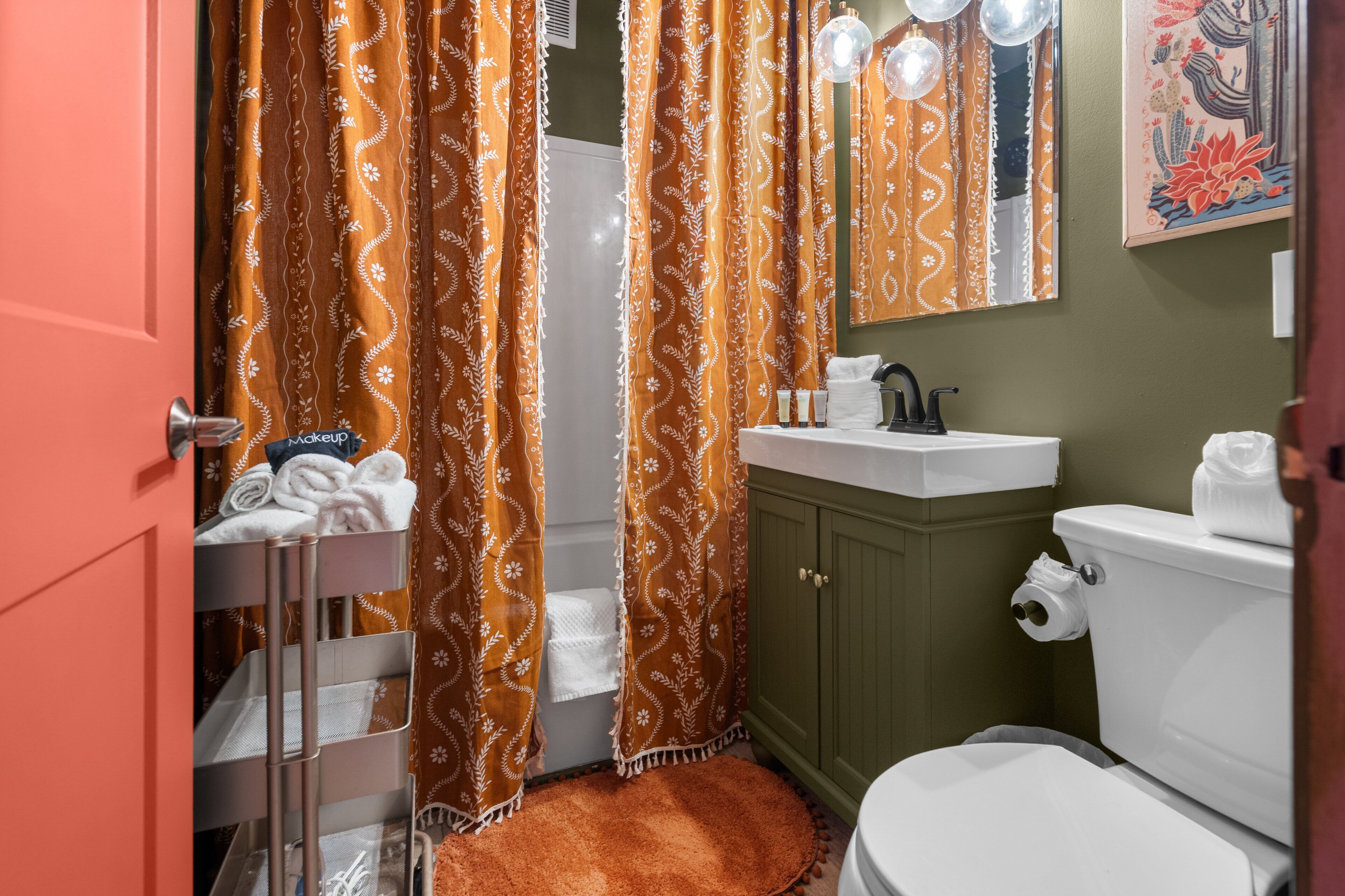 A bathroom with a toilet, sink, and shower curtain.