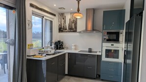 Moderni keittiö, jossa on sisäänrakennettu uuni, mikroaaltouuni ja kahvinkeitin.