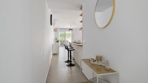Una cocina moderna con encimera de madera, un espejo redondo y un cartel que dice 'Welcome'.