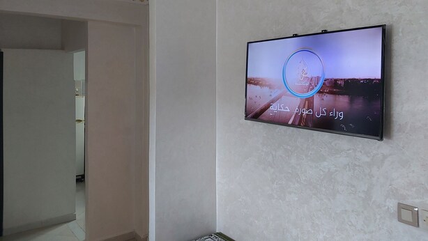 Una habitación con un televisor de montaje que muestra una vista urbana.