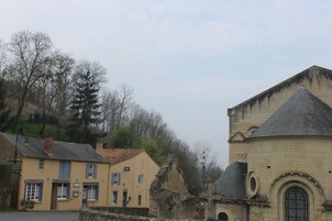 A building with a yellow facade and a stone structure with a circular window.