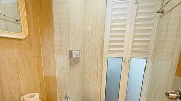 Une petite salle de bain avec un lavabo, des toilettes et une fenêtre avec des stores.