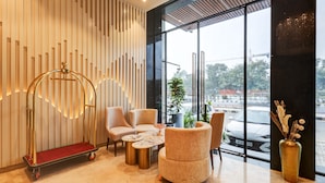 A modern lobby with a seating area, a decorative cart, and a large window offering a view of the outside. - Hotel Premier Inn (New Delhi)