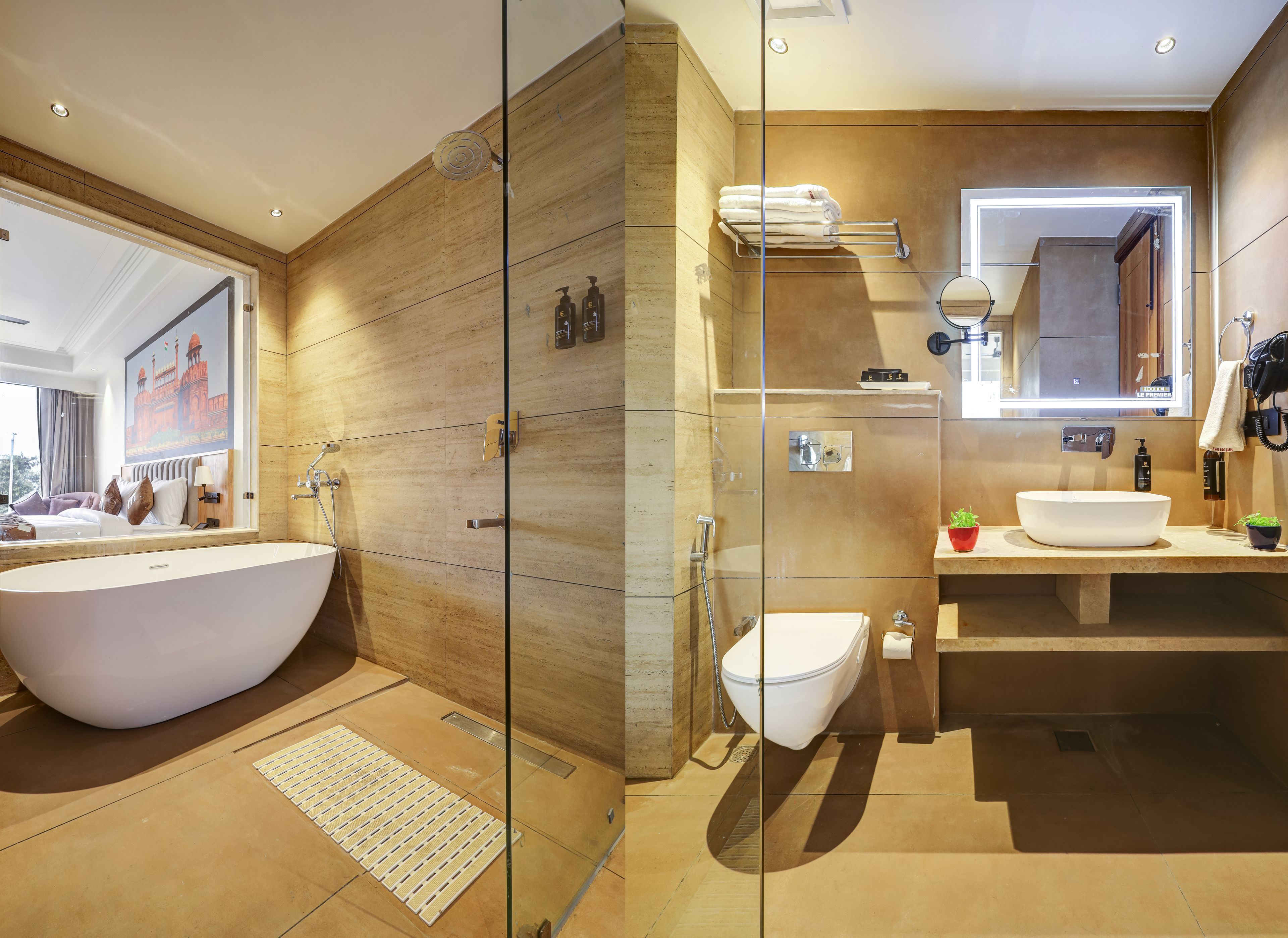 A modern bathroom with a freestanding bathtub, a toilet, and a vanity with a large mirror.