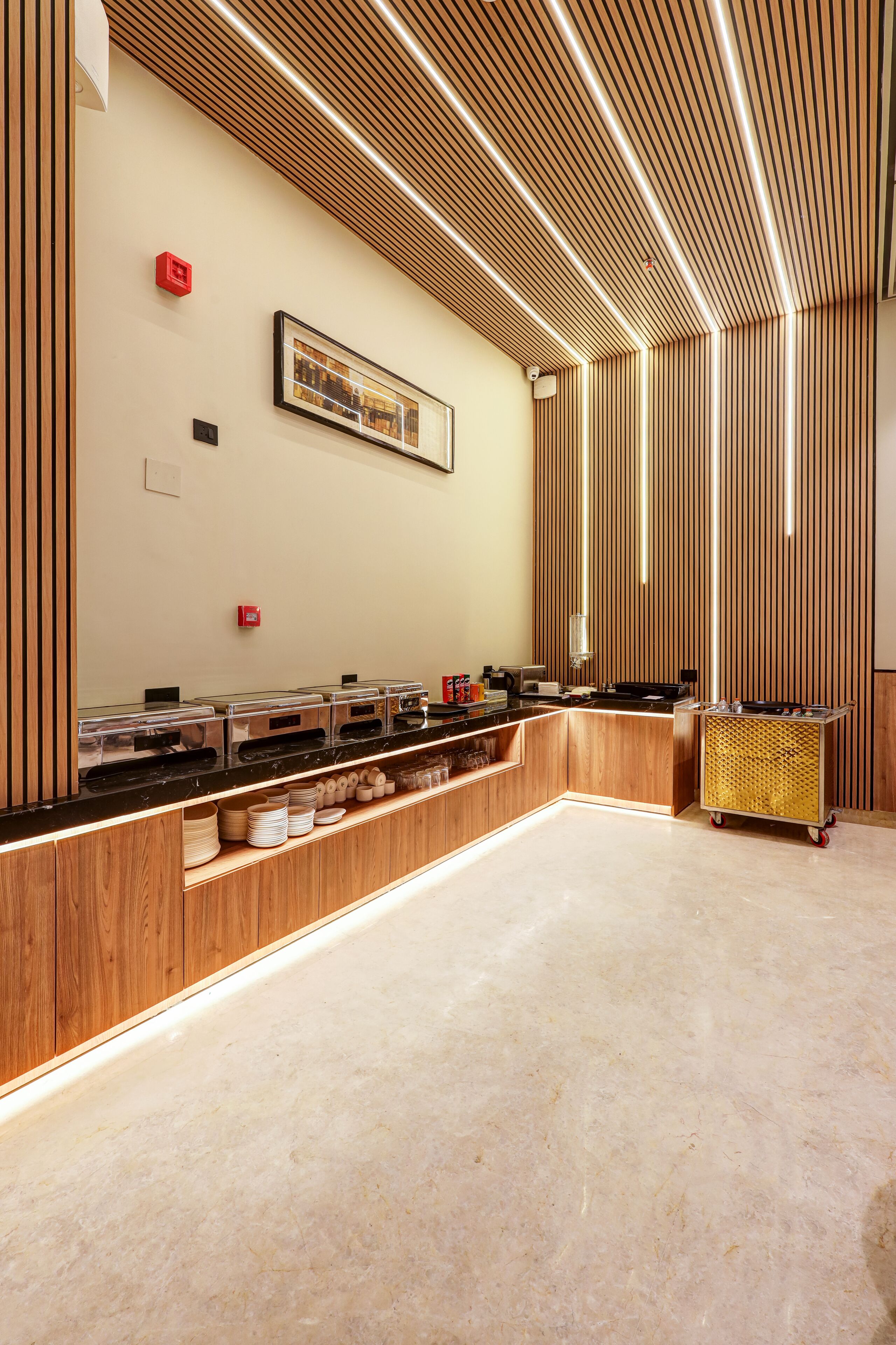 Un moderno sector de buffet con mostrador de madera, recipientes de vidrio transparente y un pequeño carro.
