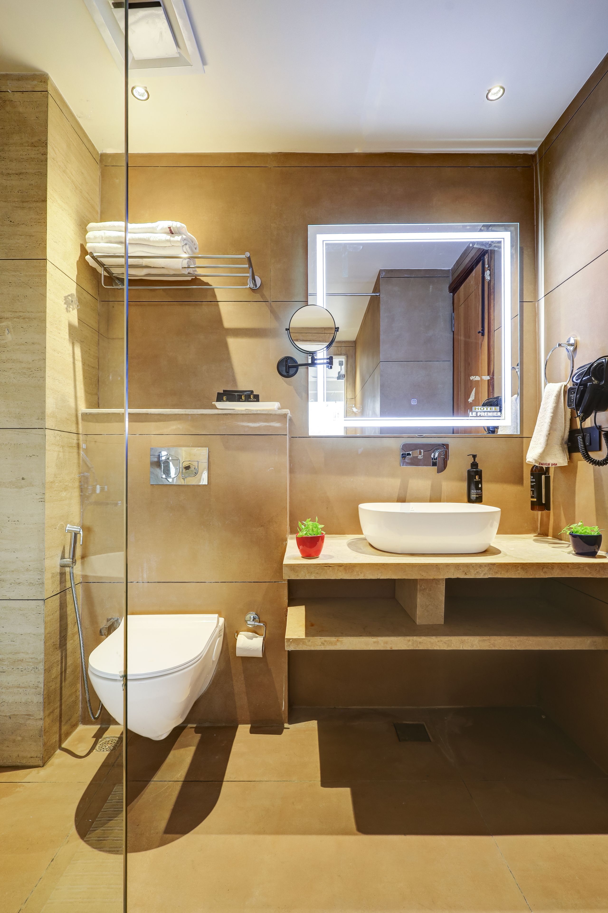 Un bagno moderno con doccia in vetro, lavandino bianco e mobile vanitario con specchio.